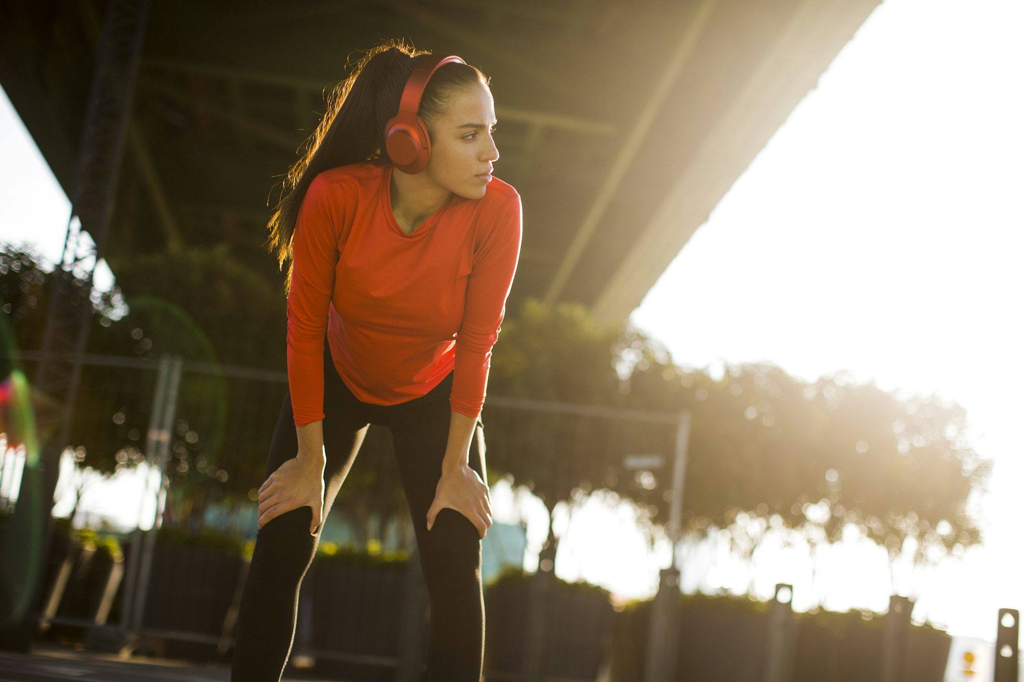 Attractive female runner taking break after jogging outdoors